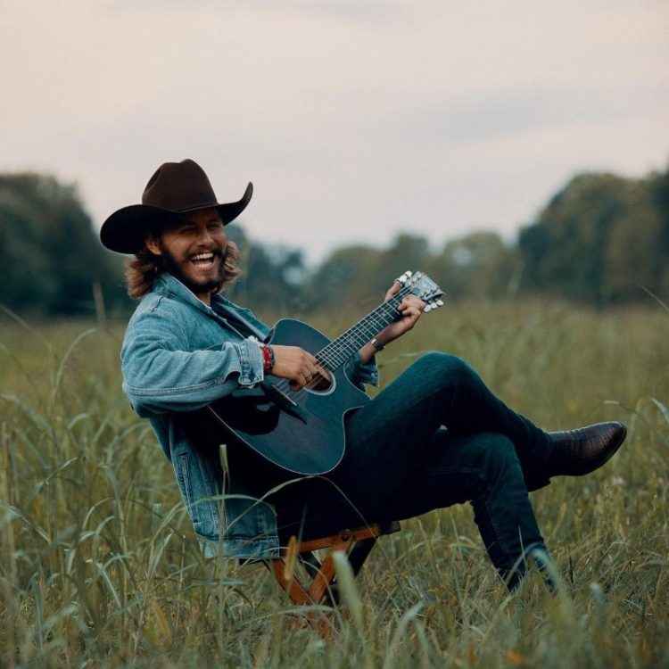 Image - American country singer-songwriter, Warren Zeiders, playing the guitar.