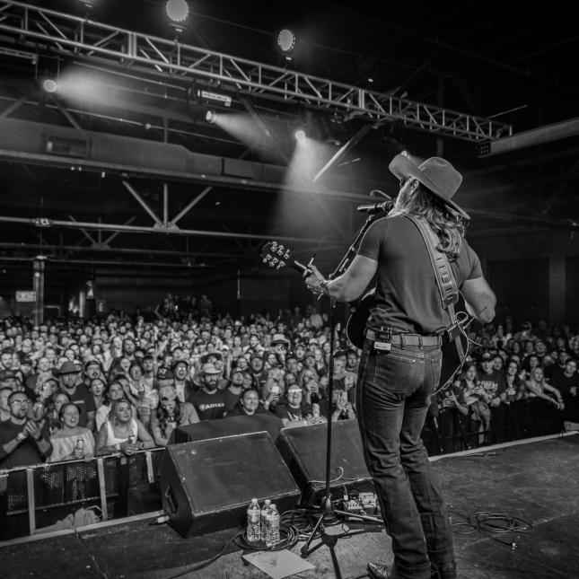 Image - American country singer-songwriter, Warren Zeiders, on stage in one of his tours/concerts.