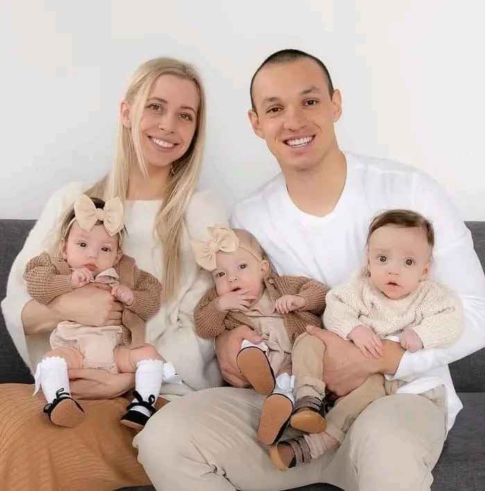 Image - Haylee Hess in a family photo with her husband, Mitchell Hess, and triplets, Lennon, Elliot, and Tommy. 